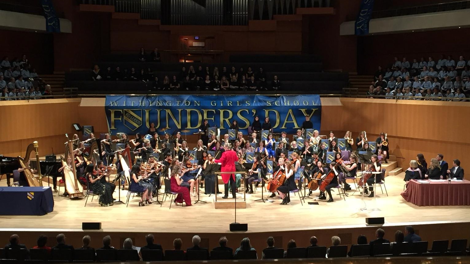 Orchestra on stage with choirs in the background.